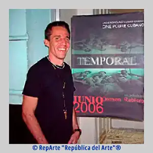 Fotografía de Demián Rabilero Del Castillo y el cartel de su cortometraje "Temporal", Colección RepArte Arte Cubano del Fondo "República del Arte"®.